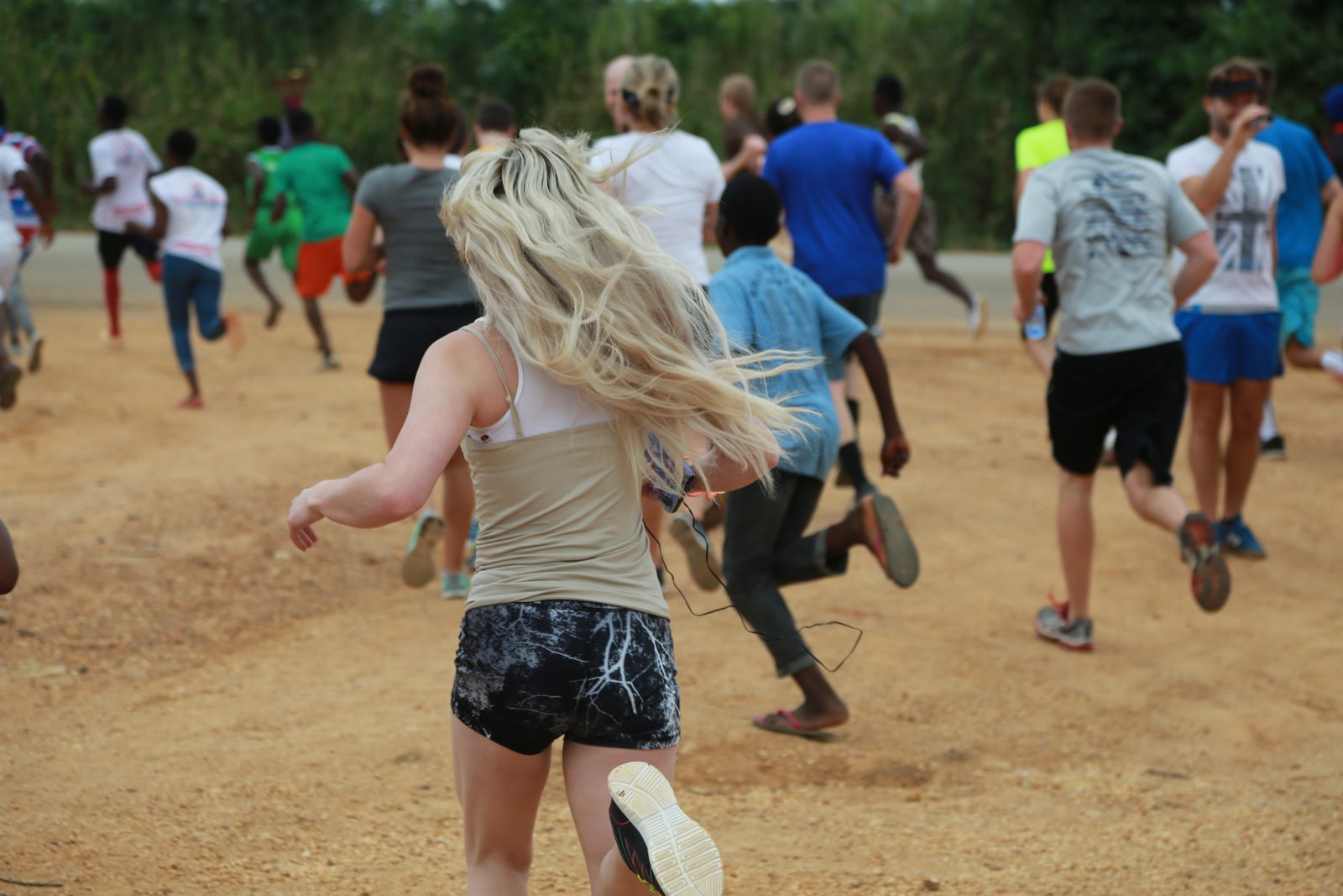 The field surges off the start on the dirt road