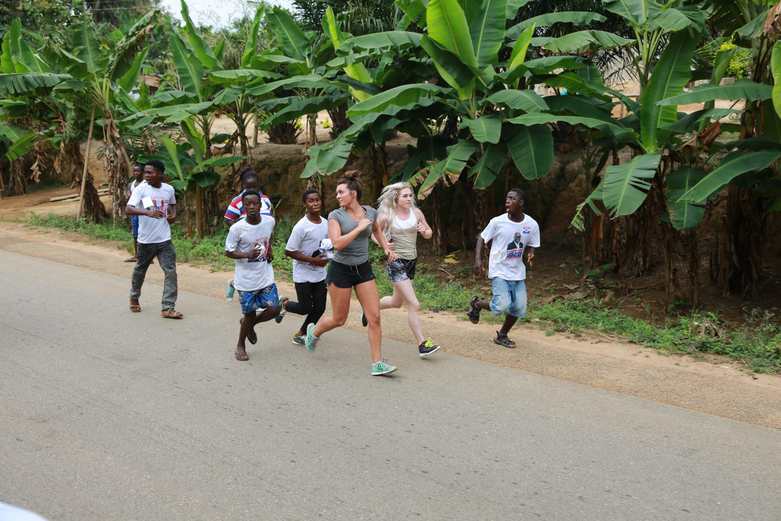 Runners jogging past banana groves