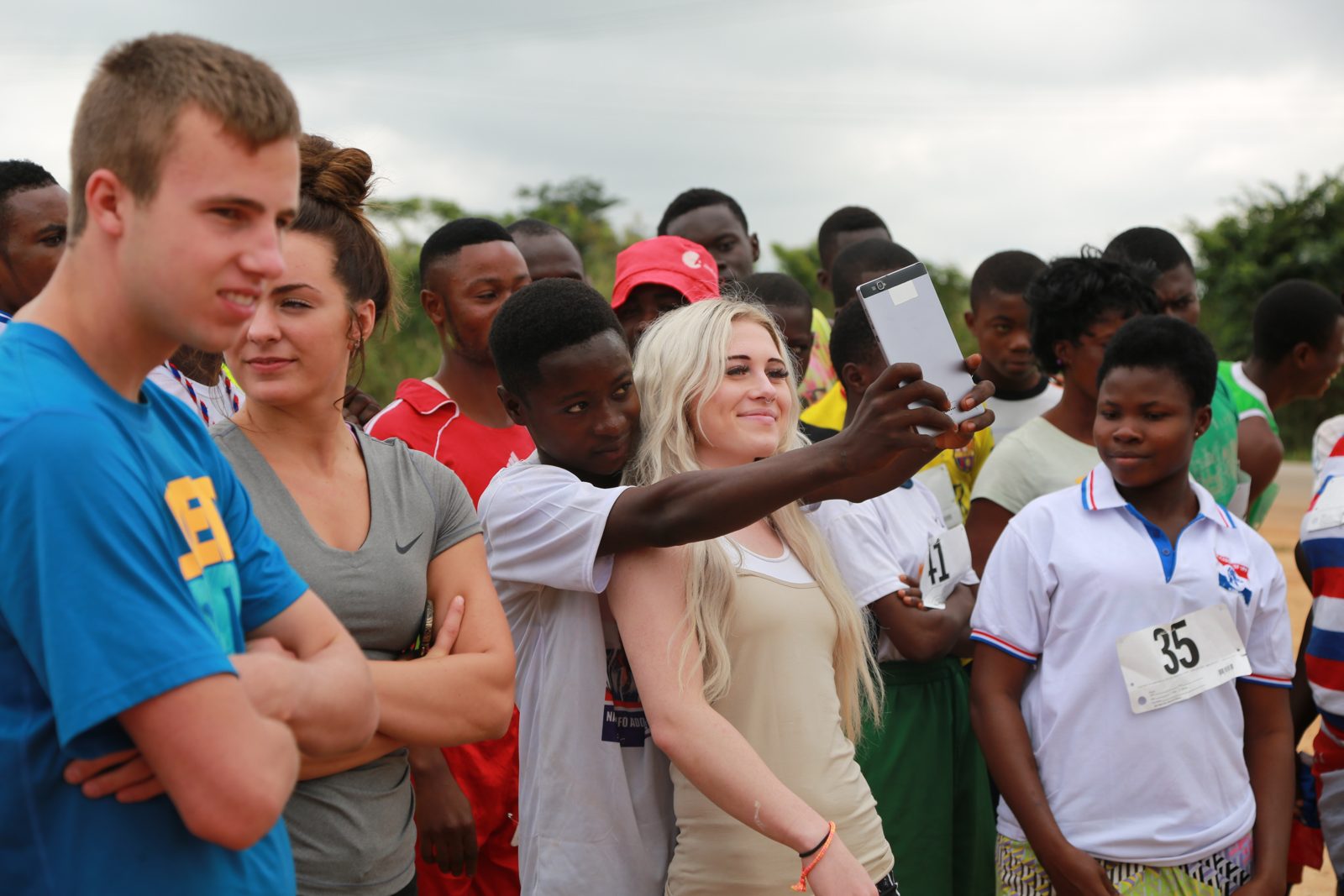 A young runner snaps a selfie with volunteers before the race