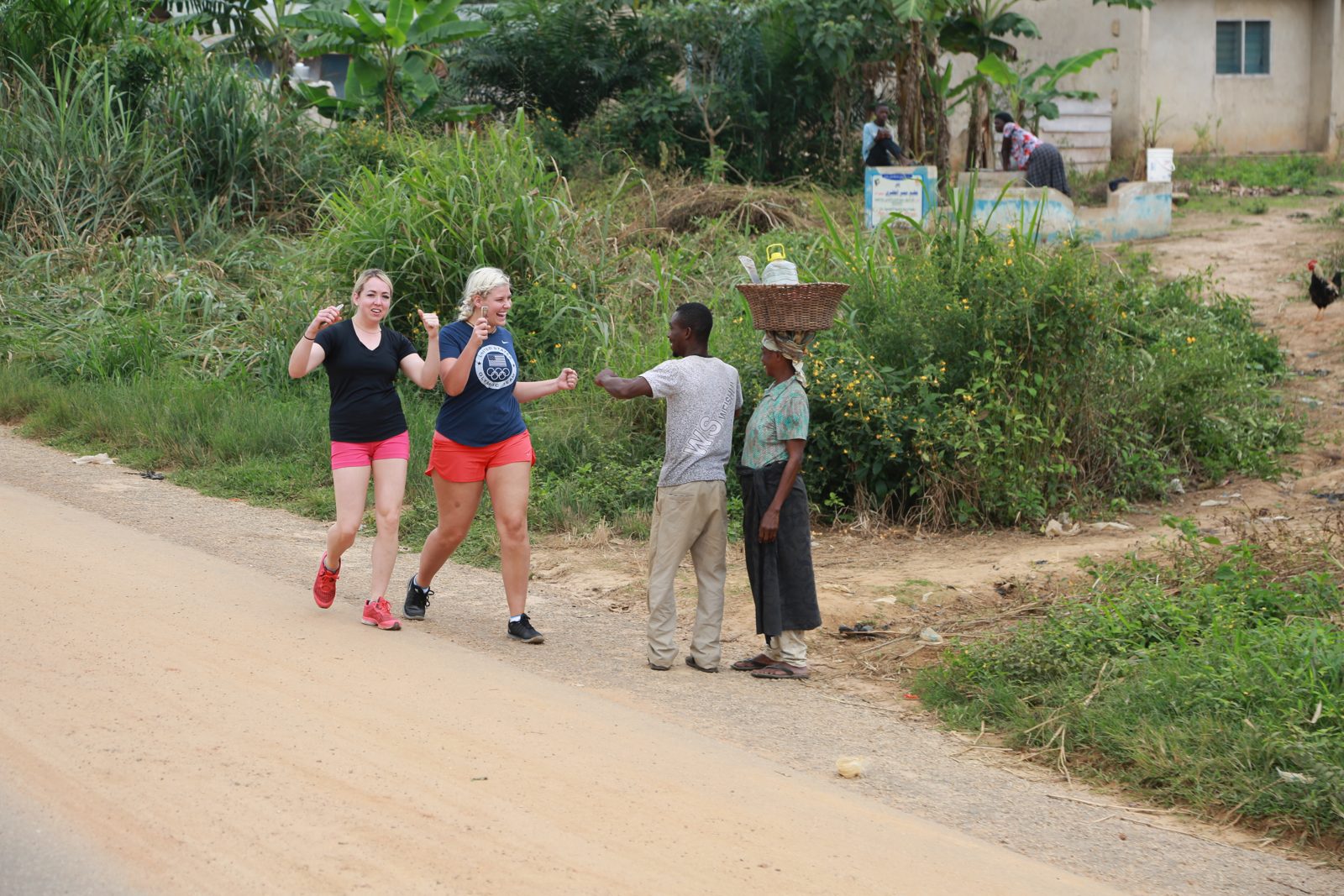 Volunteers greeting a child carrying a basket at the roadside