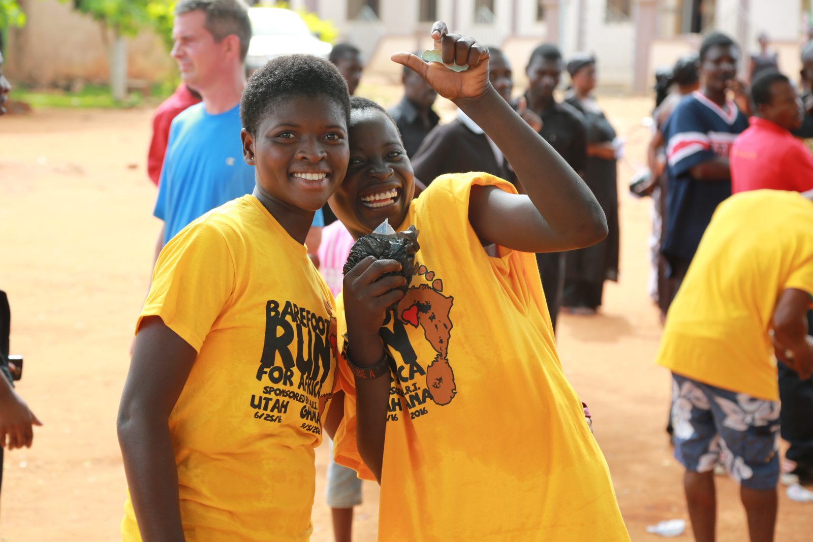 A young woman in a Barefoot Run shirt smiling in the crowd