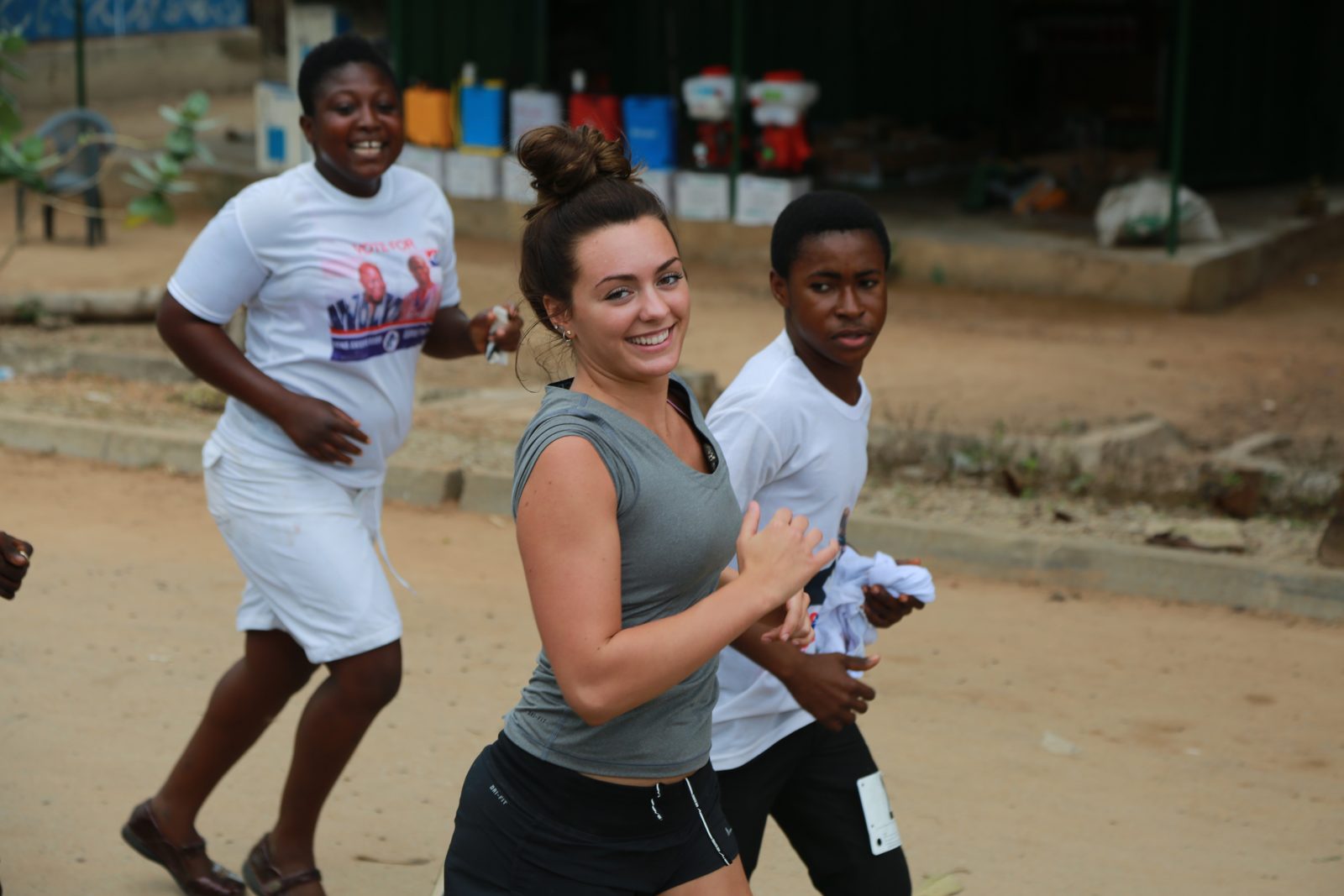 A volunteer and local runners laughing mid-stride
