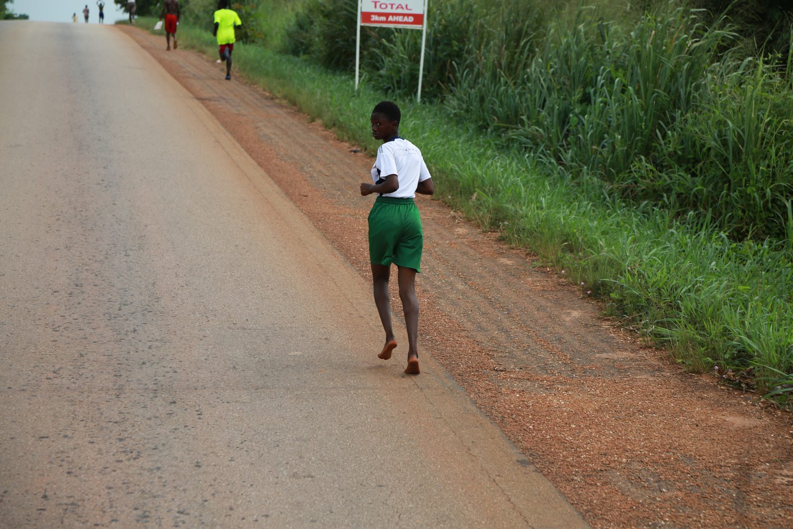 A runner holding a steady pace up the road