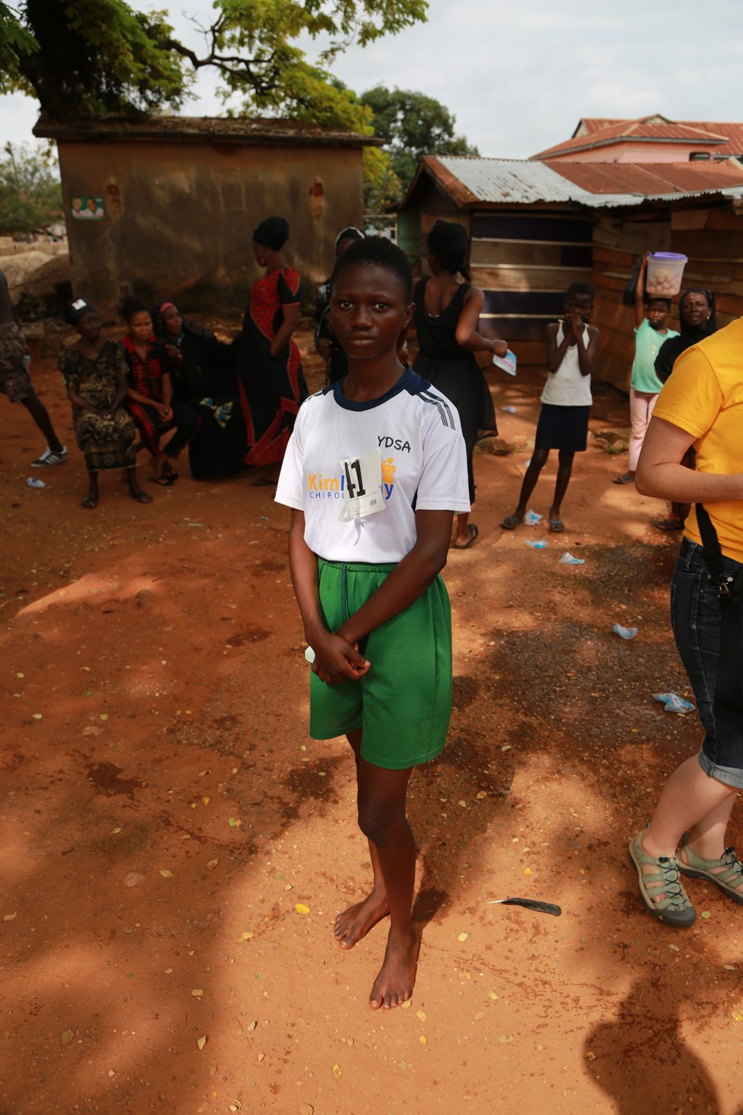 A young neighbor standing barefoot on the village road