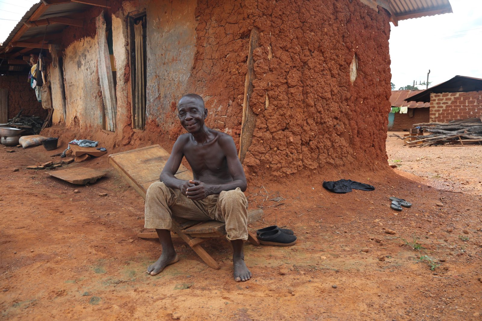 An elder seated outside his home