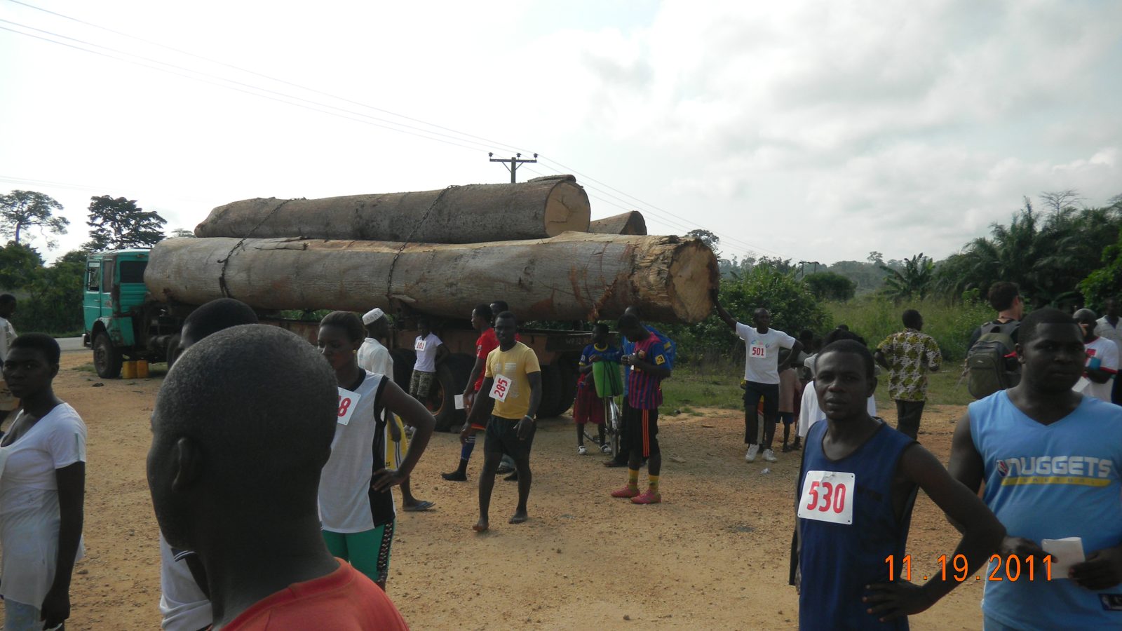Runners gathered along the course beside a timber truck