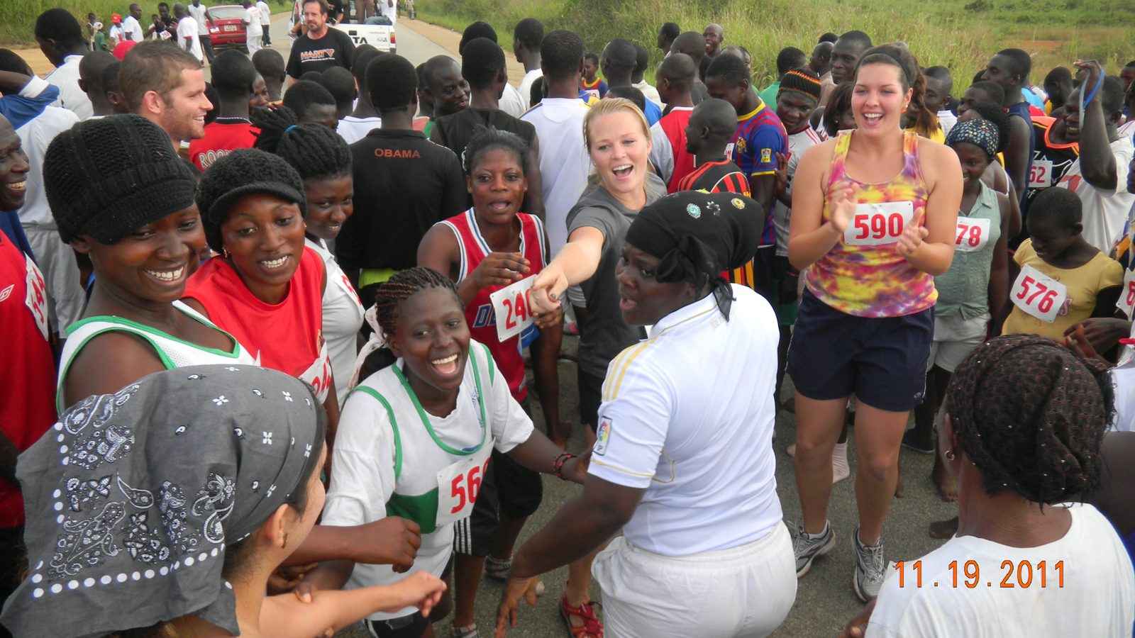 Runners and volunteers laughing and clapping together after the race
