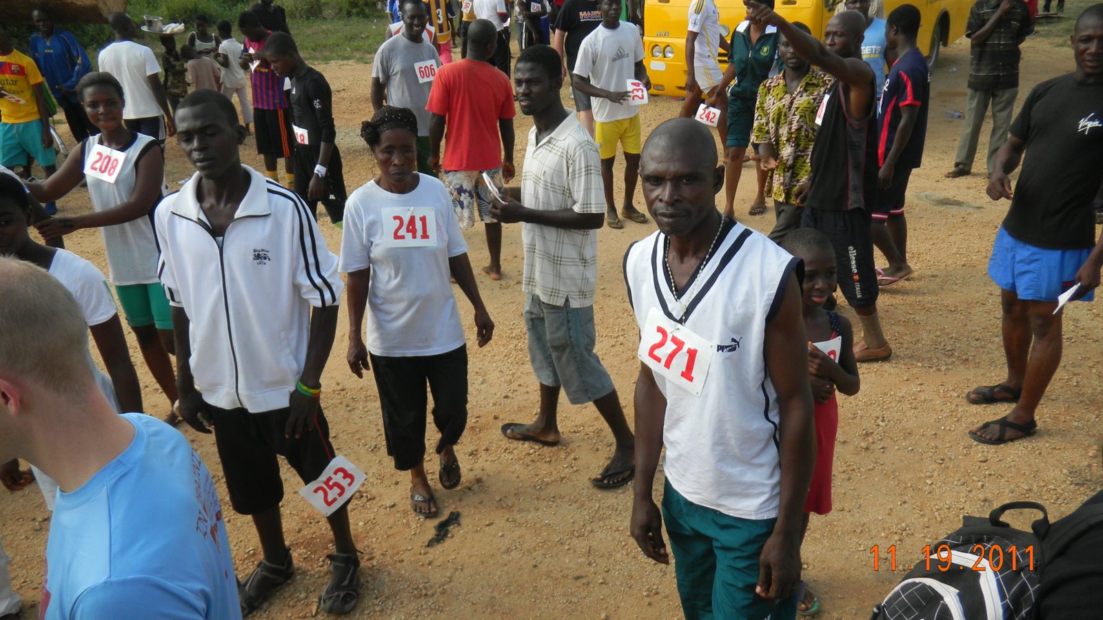 Runners wearing race bibs gathering before the start