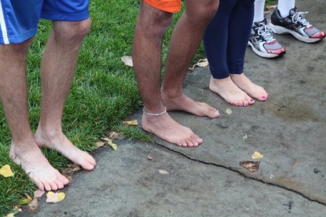 A lineup of bare feet on the pavement before the race